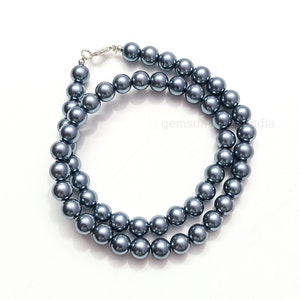 Peut inclure: Un collier de perles de faux perles grises avec un fermoir argenté.