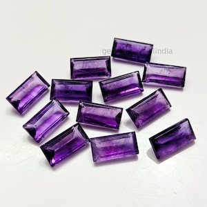 May include: A collection of rectangular, faceted amethyst gemstones. The gems are a deep purple color and are arranged on a white surface. The facets catch the light, creating a sparkling effect. The gemstones are likely for jewelry making.