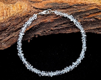 May include: A clear crystal bracelet with a silver clasp. The bracelet is made of faceted crystal beads and is strung on a silver chain.