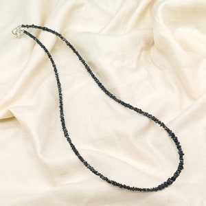 May include: A black diamond necklace made of small, rough-cut stones. The necklace is strung on a silver chain and has a simple clasp.