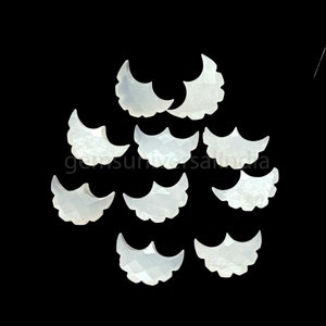 May include: Ten white, crescent-shaped, mother of pearl cabochons with scalloped edges.
