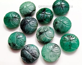 Puede incluir: Una colección de cuentas de piedras preciosas de color verde esmeralda. Cada cuenta es redonda y está tallada con un diseño de trébol de cuatro hojas. Las cuentas varían en tonalidad de verde claro a oscuro.