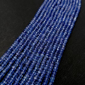 K&ouml;nnte beinhalten: Eine Str&auml;hne blauer Edelsteinperlen. Die Perlen sind facettiert und haben eine leicht unregelm&auml;&szlig;ige Form. Die Perlen sind auf einem durchsichtigen Faden aufgef&auml;delt.