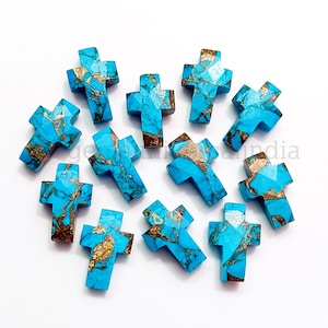May include: Twelve turquoise and gold cross-shaped gemstone beads. The beads are approximately 1 inch in size and have a marbled pattern.