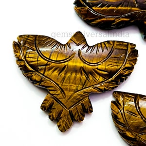 May include: Two carved tiger's eye stone owls. The owls are detailed with feathers and have a golden brown color.