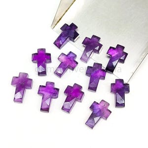 May include: Ten purple amethyst cross shaped gemstone beads. The beads are faceted and have a shiny finish.