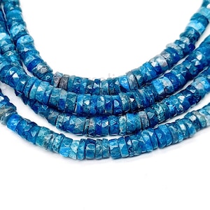 May include: A strand of blue apatite beads, faceted and with a slightly irregular shape. The beads are strung together to form a necklace or bracelet.
