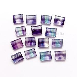 May include: Assortment of 15 purple, blue, and green fluorite rectangular gemstones. The gemstones are faceted and have a variety of shades and patterns.