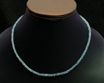 May include: A light blue aquamarine gemstone necklace with small round beads.