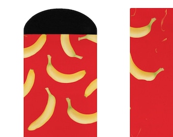 May include: A pair of red socks with a pattern of yellow bananas. The socks have black toe and heel areas.