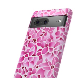 May include: Pink phone case with a floral pattern. The case has a raised camera bump and a black trim.