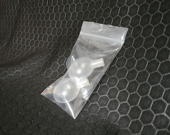 May include: Two clear plastic dog squeaky toys in a clear plastic bag. The toys are round with a small hole at the top for a squeaker.