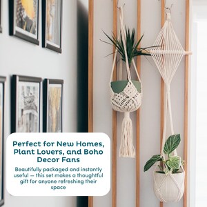May include: Two macrame plant hangers with plants in white and green pots. One hanger has a diamond design, the other has a tassel. The background includes a wooden slat wall and framed artwork. The image text says "Perfect for New Homes, Plant Lovers, and Boho Decor Fans."