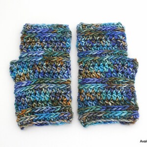 May include: A pair of blue, green, and brown fingerless gloves with a crocheted design.