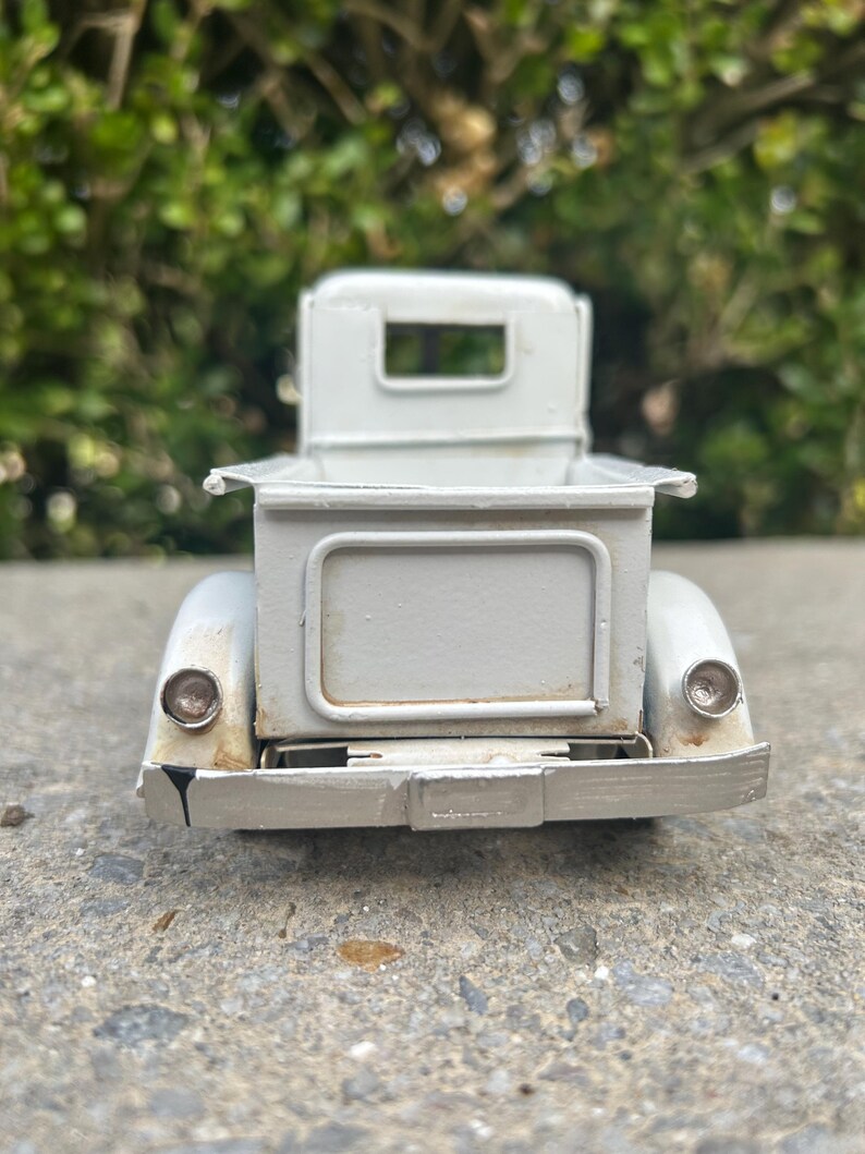 A white metal object, possibly a car or a piece of machinery, is shown in the image.