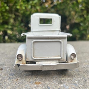 A white metal object, possibly a car or a piece of machinery, is shown in the image.