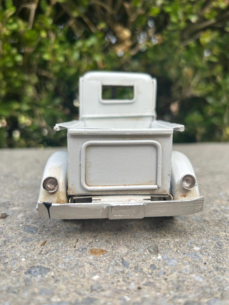 A white metal object, possibly a car or a piece of machinery, is shown in the image.