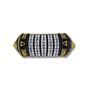 Puede incluir: Un pin de metal de color dorado con forma de cerradura de combinación con detalles negros y letras blancas que deletrean el alfabeto en cada uno de los cinco cilindros giratorios.