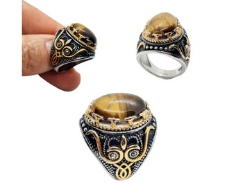 Anello in acciaio inossidabile 316L con pietra dura occhio di tigre e marcasite laterali colore argento imbrunito con rifinitura dorata