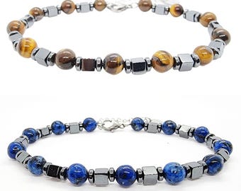 Puede incluir: Dos pulseras de cuentas con cierres plateados. La pulsera superior tiene cuentas de ojo de tigre marrón y cuentas de hematites negras. La pulsera inferior tiene cuentas de lapislázuli azul y cuentas de hematites negras.