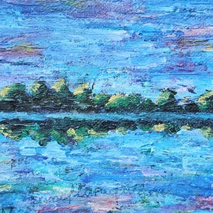 May include: An abstract landscape painting with a textured, impasto style. The artwork depicts a body of water reflecting a line of trees under a blue sky with hints of pink and yellow. The water and sky are rendered in shades of blue.