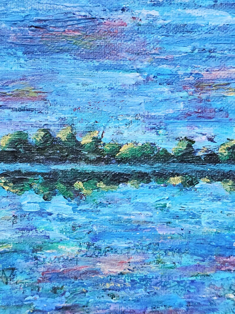 May include: An abstract landscape painting with a textured, impasto style. The artwork depicts a body of water reflecting a line of trees under a blue sky with hints of pink and yellow. The water and sky are rendered in shades of blue.
