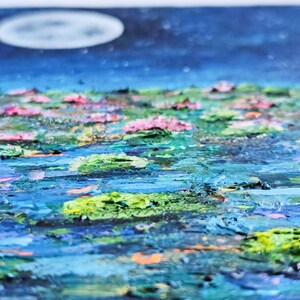 K&ouml;nnte beinhalten: Impressionistische Malerei eines mondbeschienenen Teichs mit Seerosen. Das Kunstwerk zeigt einen dunkelblauen Himmel mit einem weichen, wei&szlig;en Mond. Das Wasser ist eine Mischung aus Blau und Gr&uuml;n, mit rosa und gr&uuml;nen Seerosen.