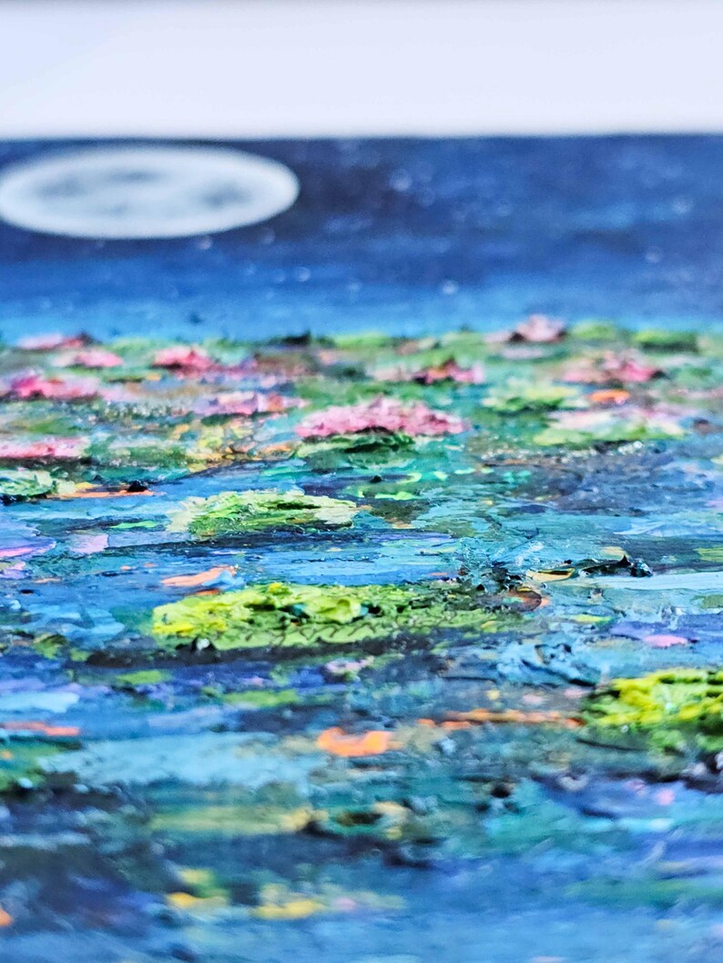 K&ouml;nnte beinhalten: Impressionistische Malerei eines mondbeschienenen Teichs mit Seerosen. Das Kunstwerk zeigt einen dunkelblauen Himmel mit einem weichen, wei&szlig;en Mond. Das Wasser ist eine Mischung aus Blau und Gr&uuml;n, mit rosa und gr&uuml;nen Seerosen.