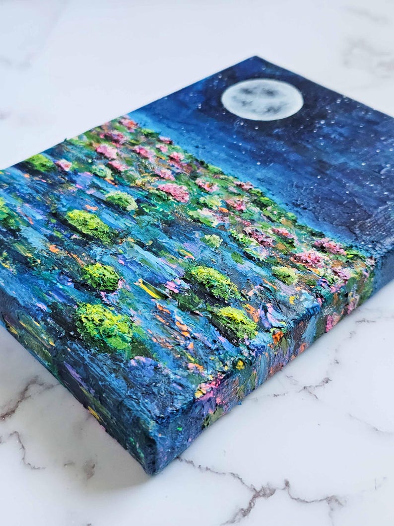 K&ouml;nnte beinhalten: Strukturiertes Acrylgem&auml;lde einer Nachtlandschaft mit Vollmond und Sternen. Das Kunstwerk zeigt einen H&uuml;gel mit rosa und gr&uuml;n strukturiertem Laub, gemalt mit dicken Pinselstrichen. Die Farbpalette umfasst Blau-, Gr&uuml;n-, Rosa- und Wei&szlig;t&ouml;ne.