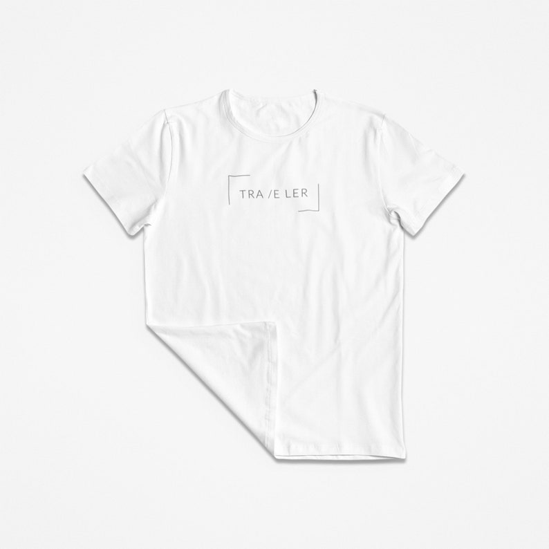 May include: White t-shirt with a minimalist design featuring the text "TRA/ELER" in a box.
