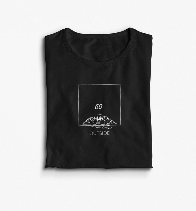 Peut inclure: T-shirt noir avec un graphique blanc repr&eacute;sentant une cha&icirc;ne de montagnes avec un soleil et le texte "GO OUTSIDE" dans un cadre blanc.