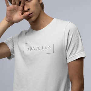 May include: White t-shirt with a black box and the text "TRA/ELER" inside.