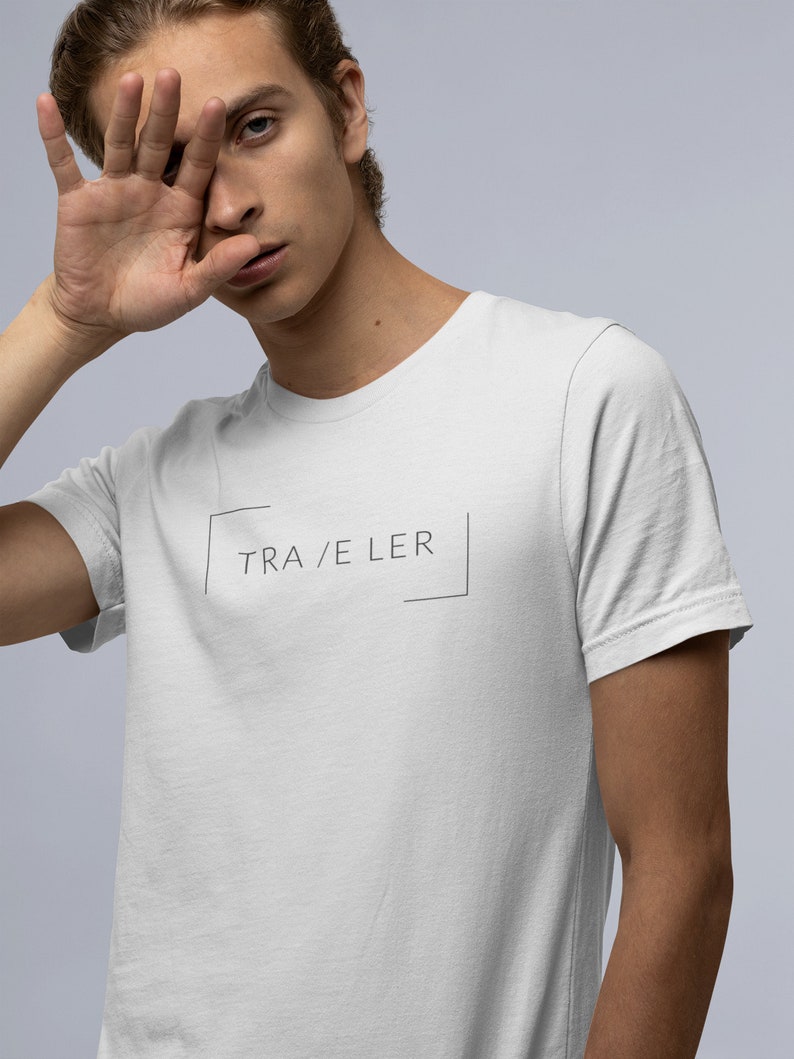 May include: White t-shirt with a black box and the text "TRA/ELER" inside.