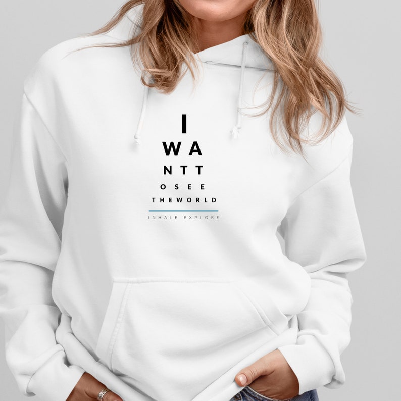 May include: White hoodie with black text that reads "I WANT TO SEE THE WORLD" and "INHALE EXPLORE" in smaller text below.