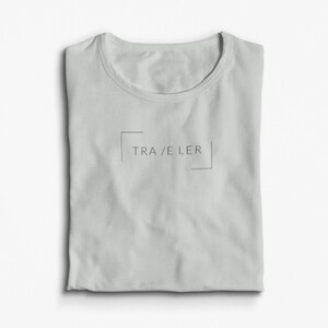 May include: A light gray t-shirt with a simple design featuring the word "TRAVELER" in a box.