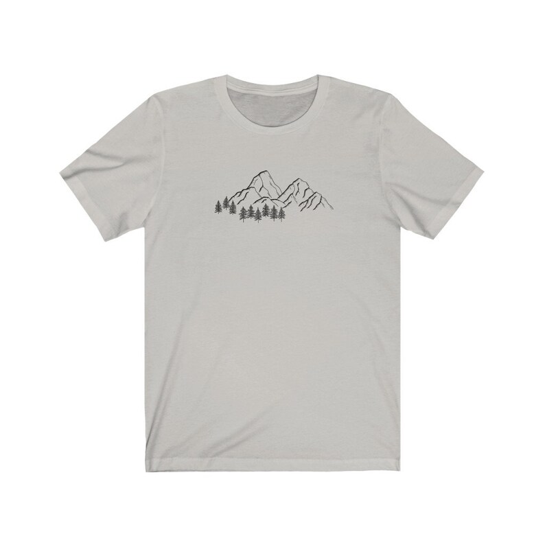 May include: A light gray t-shirt with a black line drawing of mountains and trees on the front.