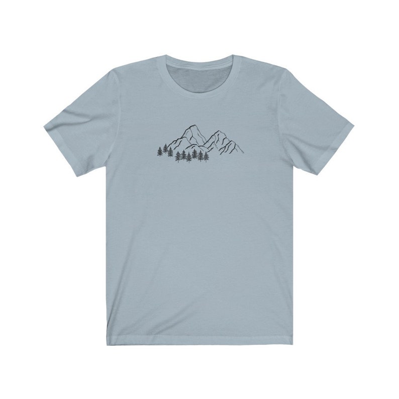 May include: A light blue t-shirt with a black line drawing of mountains and trees on the front.