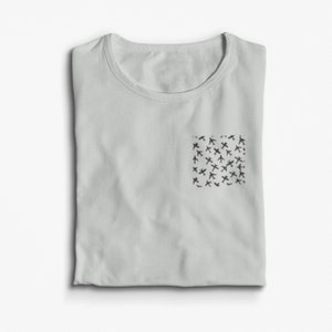 May include: A light grey t-shirt with a small pocket on the left side. The pocket has a black and white pattern of aeroplanes.