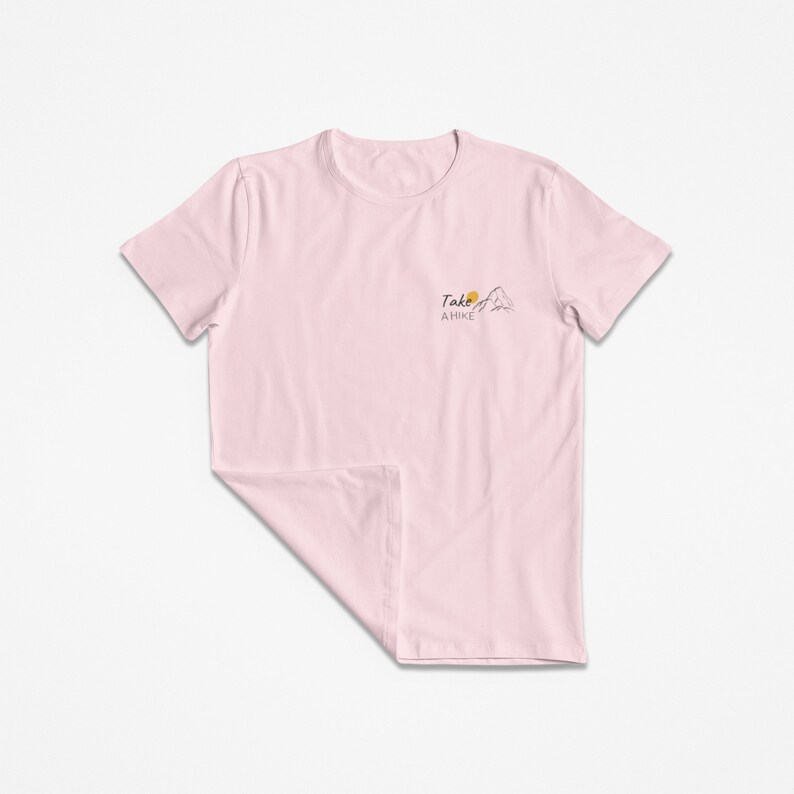 May include: A pink t-shirt with a graphic of a mountain and the text "Take a Hike" on the front.