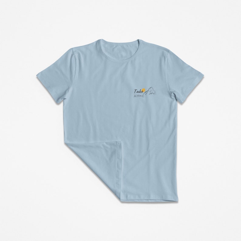 May include: A light blue t-shirt with a graphic of a mountain and a sun with the text "Take a Hike" on the front.