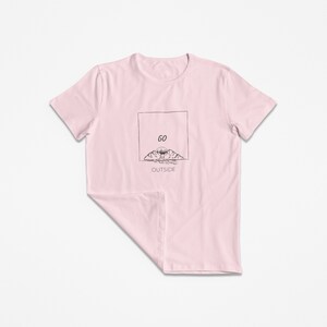 Peut inclure: T-shirt rose avec un graphique noir de montagnes et un soleil avec le texte "GO OUTSIDE" dans un encadr&eacute;.