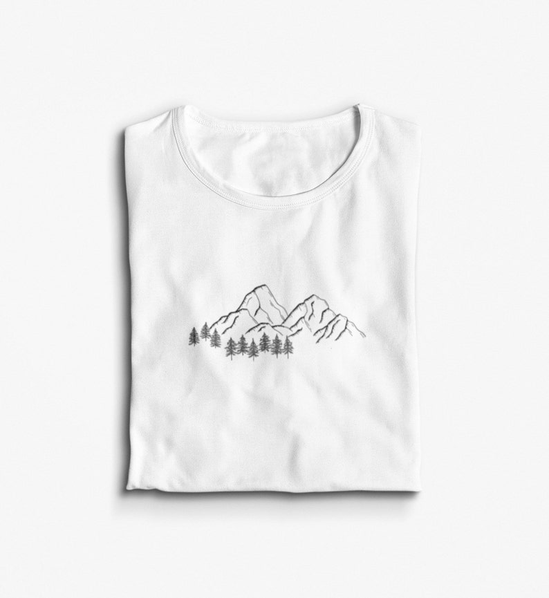 May include: White t-shirt with a black line drawing of mountains and trees.
