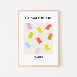Puede incluir: Un póster enmarcado con ositos de goma multicolores sobre un fondo beige claro. Los ositos son rojos, amarillos, naranjas, verdes, azules y rosas. El texto "GUMMY BEARS" y "PARIS" se muestra, con "Les Oursons Gommuex" debajo.