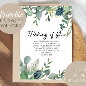 May include: A printable "Thinking of You" card with floral watercolor accents. The card features the text "Thinking of You" and a Bible verse from Romans 15:13. The design includes green eucalyptus and blue thistle illustrations.