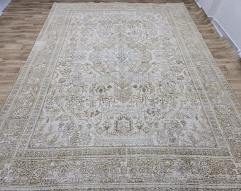 Può includere: Un tappeto vintage color crema con un motivo floreale dettagliato in una tonalità di marrone più scuro. Il tappeto ha un aspetto usurato e invecchiato, il che aggiunge al suo fascino antico.