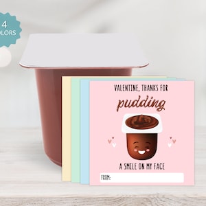 May include: A pink Valentine's Day card with a cartoon pudding cup with a smiling face. The card says "Valentine, thanks for pudding, a smile on my face." There is a space to write "From:"