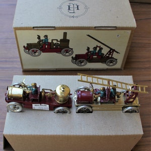 Tin Toy Fire truck and firemen, in the original box with certificates. Very good condition.
