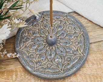 May include: Gray ceramic incense holder with a gold mandala design. The holder has a small hole in the center for incense sticks.