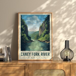 May include: A vintage-style poster with a blue and green illustration of a river flowing through a canyon. The text "CANEY FORK RIVER TENNESSEE" is printed in white at the bottom of the poster.