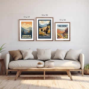 May include: Three framed art prints with nature scenes. The prints are 28 x 43 cm, 33 x 48 cm, and 28 x 36 cm. The prints feature text that reads "The Great Smoky Mountains", "Yellowstone National Park", and "Big Bend". The frames are brown.